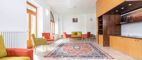 A modern living room with a sofa, chairs, a coffee table, and a rug.