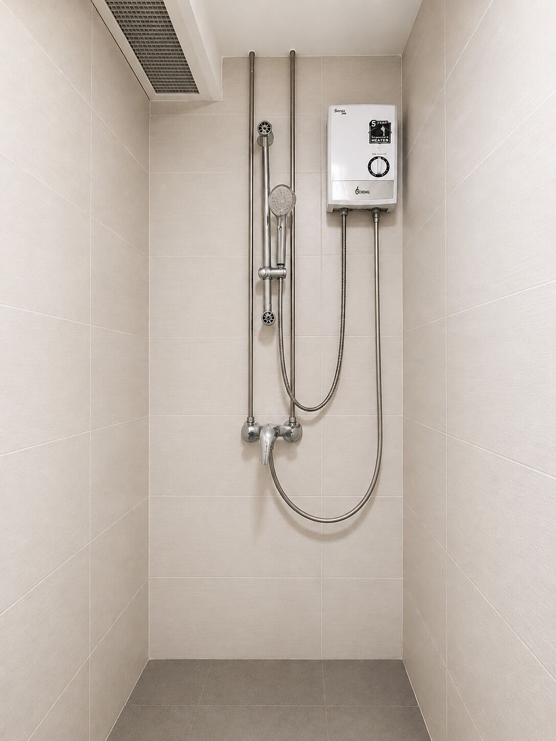 A shower with a control panel, a handheld showerhead, and a handheld shower attachment.
