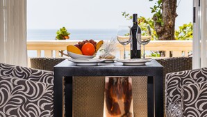 A table with a fruit bowl, wine glass, and bottle, overlooking a beach. - Club Punta Fuego (Nasugbu)