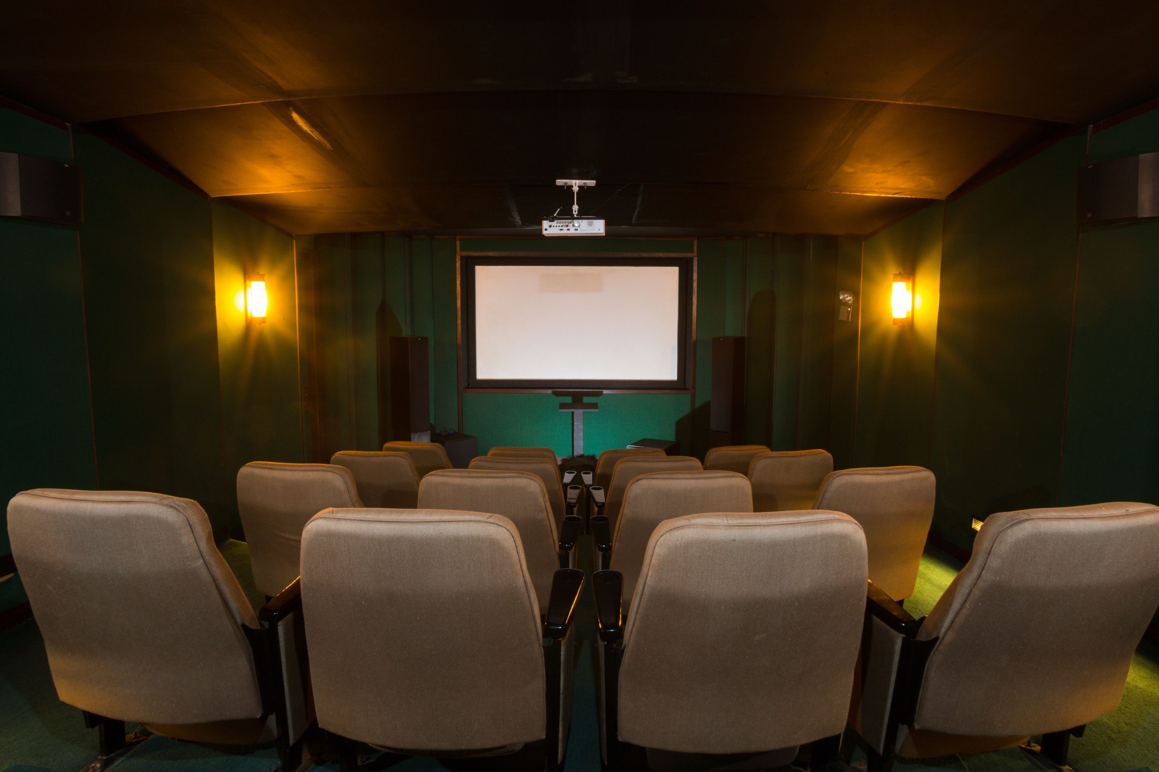 A movie theater with rows of seats facing a large screen.