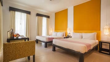 A hotel room with two beds, a dining table, and a chair.