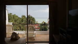 Habitación de hotel con balcón, cama y televisión.