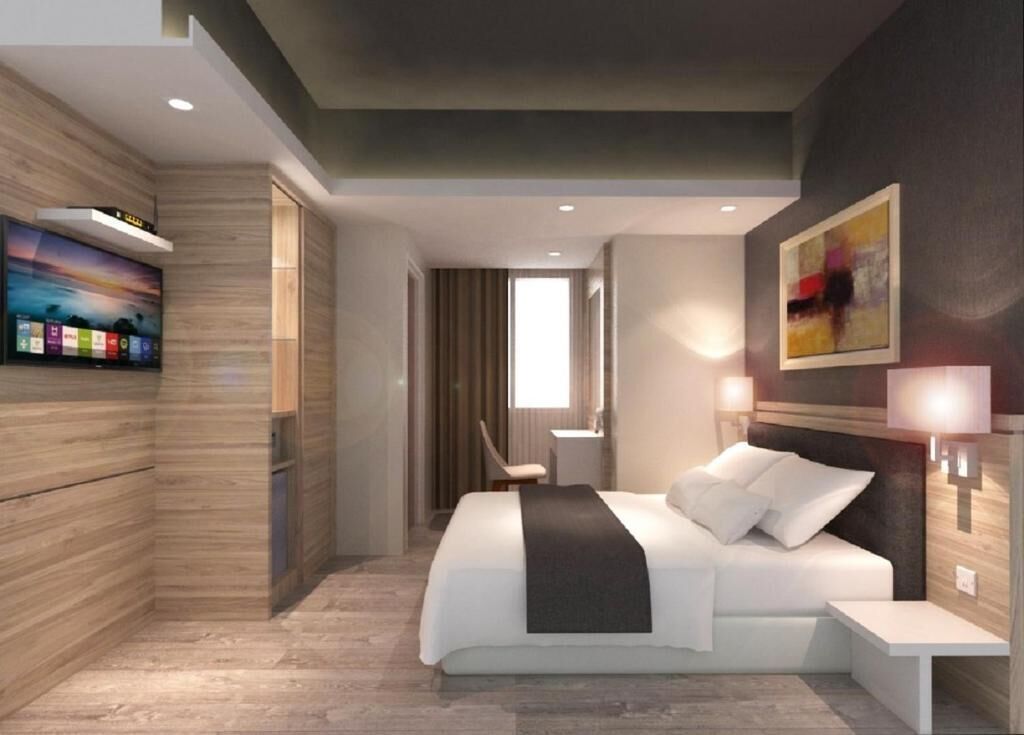 A modern hotel room with a large bed, a flat-screen TV mounted on the wall, a bedside table, and a painting on the wall.