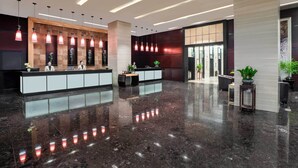 A modern lobby with a reception desk, pendant lighting, and a polished marble floor. - Zhengfangyuan International Hotel (Zhengzhou)