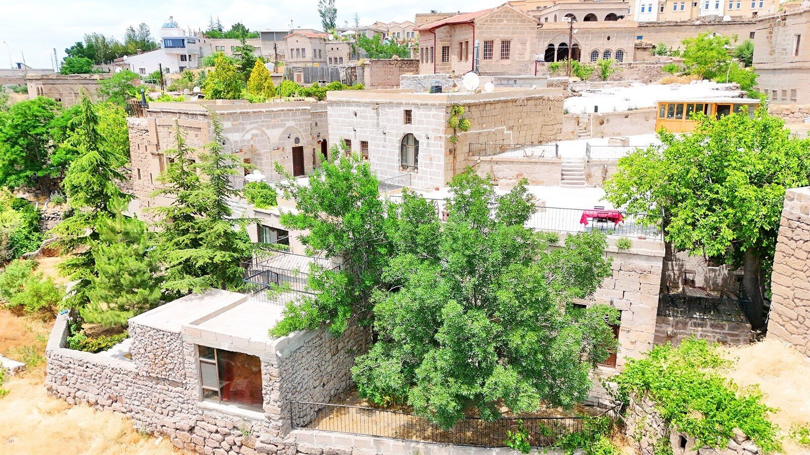 A historic stone building with a courtyard surrounded by trees.
