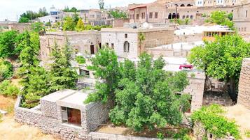 A historic stone building with a courtyard surrounded by trees.