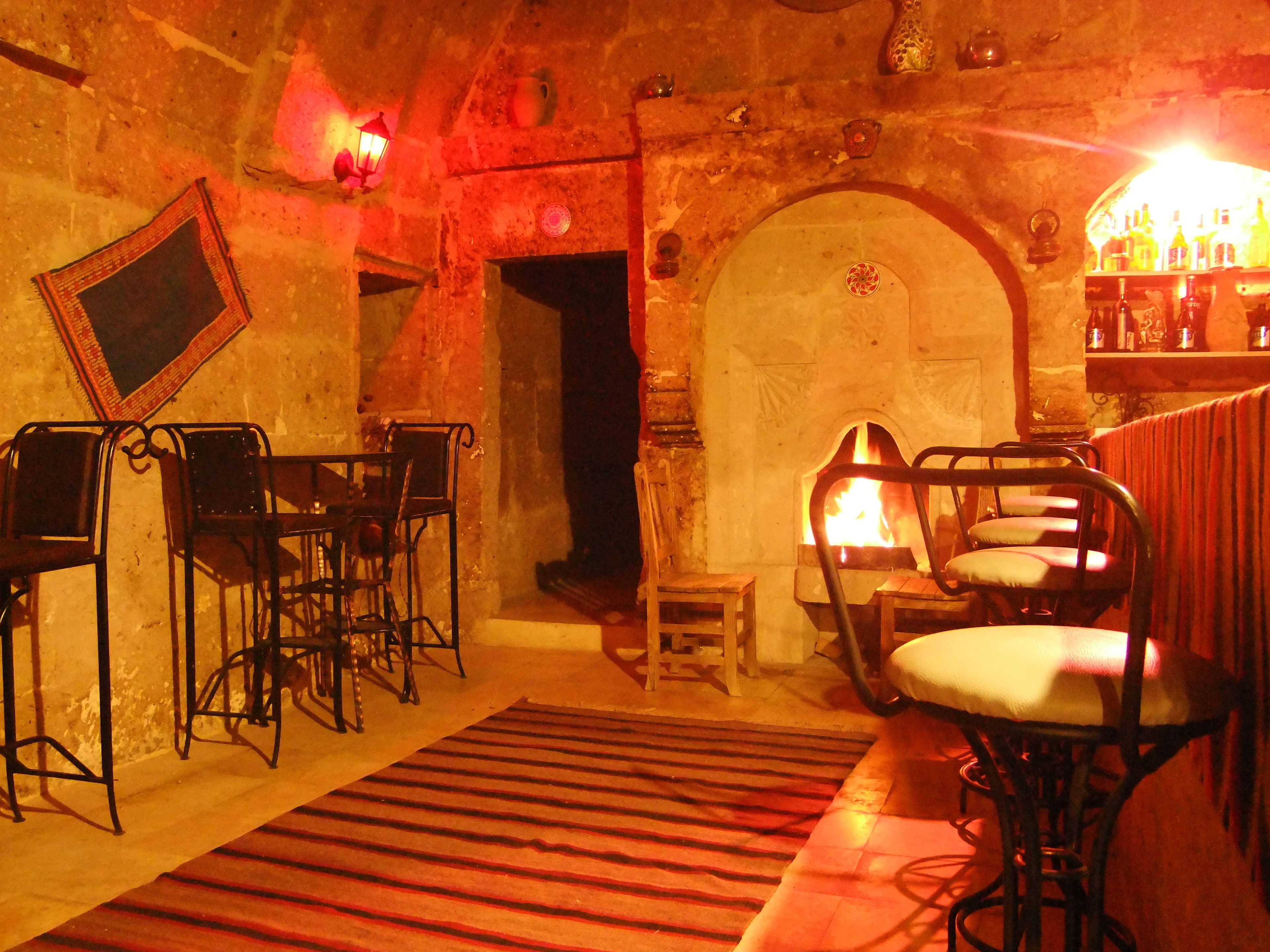 Um quarto acolhedor com lareira, móveis de madeira e um espaço bar.