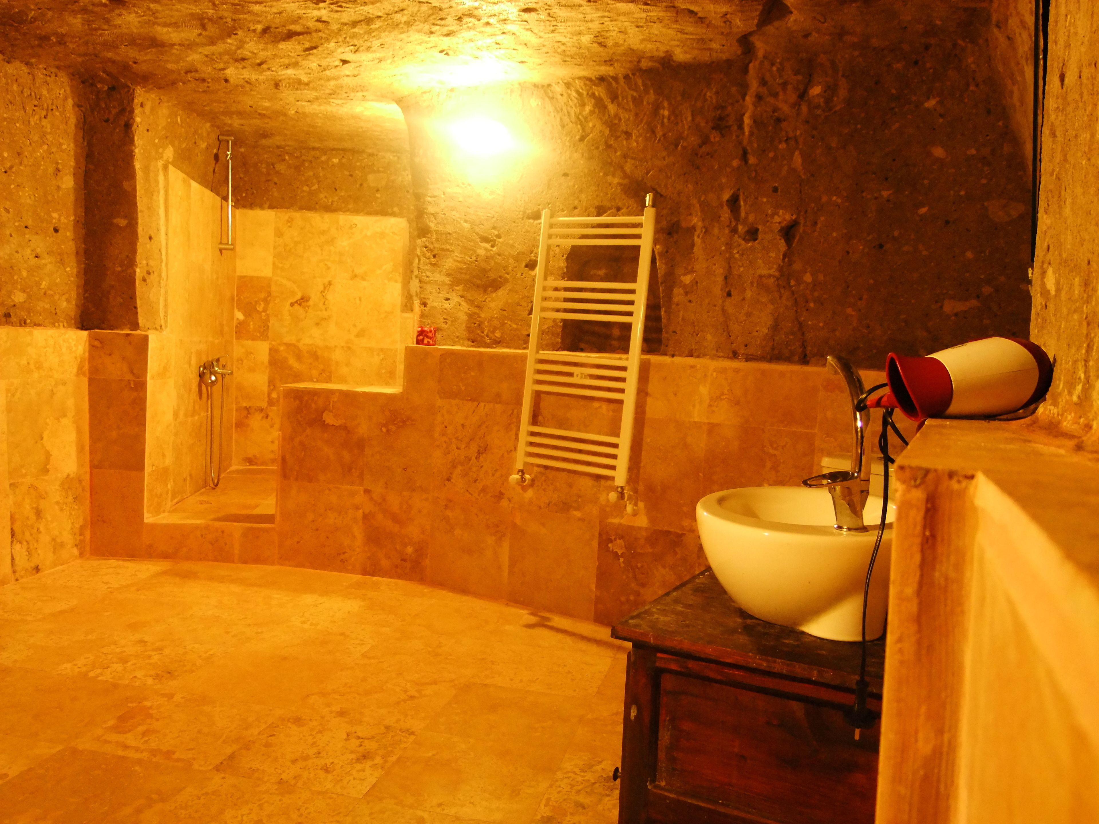 Un baño rústico con una bañera, ducha y lavamanos.