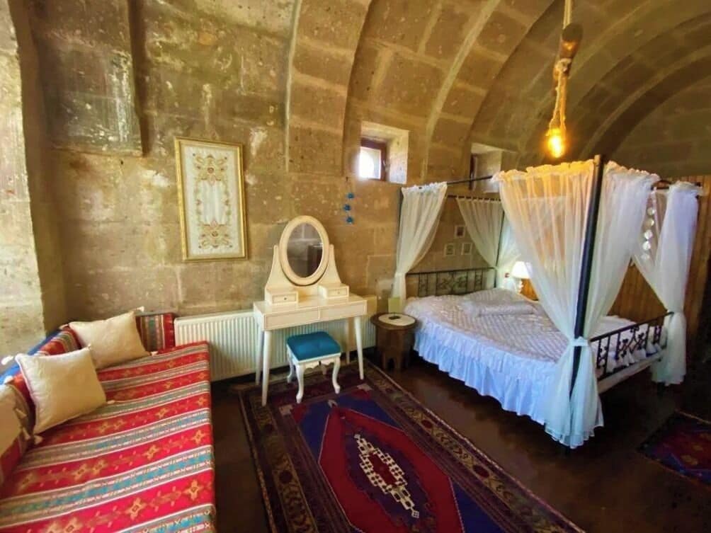 A room with a bed, a desk, a chair, and a mirror.