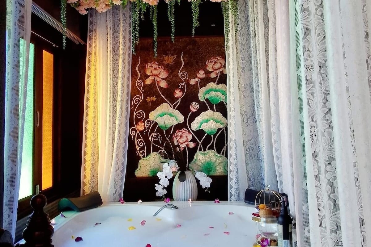 Une pièce avec une table mise pour le dîner, décorée de fleurs et de bougies.