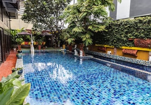 Una piscina al aire libre, tumbonas