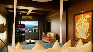 Une chambre d’hôtel avec un balcon, un lit avec des oreillers, un téléviseur diffusant Netflix et un élément décoratif mural.