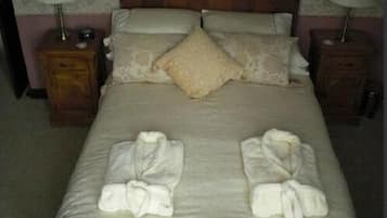 Un lit bien fait, avec deux jeux de serviettes pliés au pied du lit.