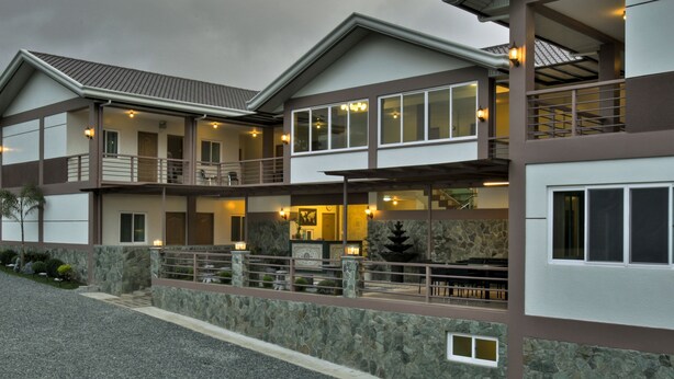 A multi-story hotel with a stone facade, balconies, and outdoor seating areas. - Tagaytay Wingate Manor (Tagaytay)