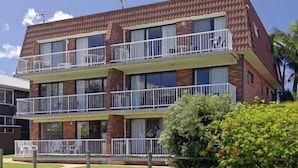 A two-story building with balconies and a brick facade. - Main Beach Apartments (Byron Bay)