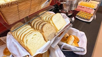 A buffet with various bread and pastries.