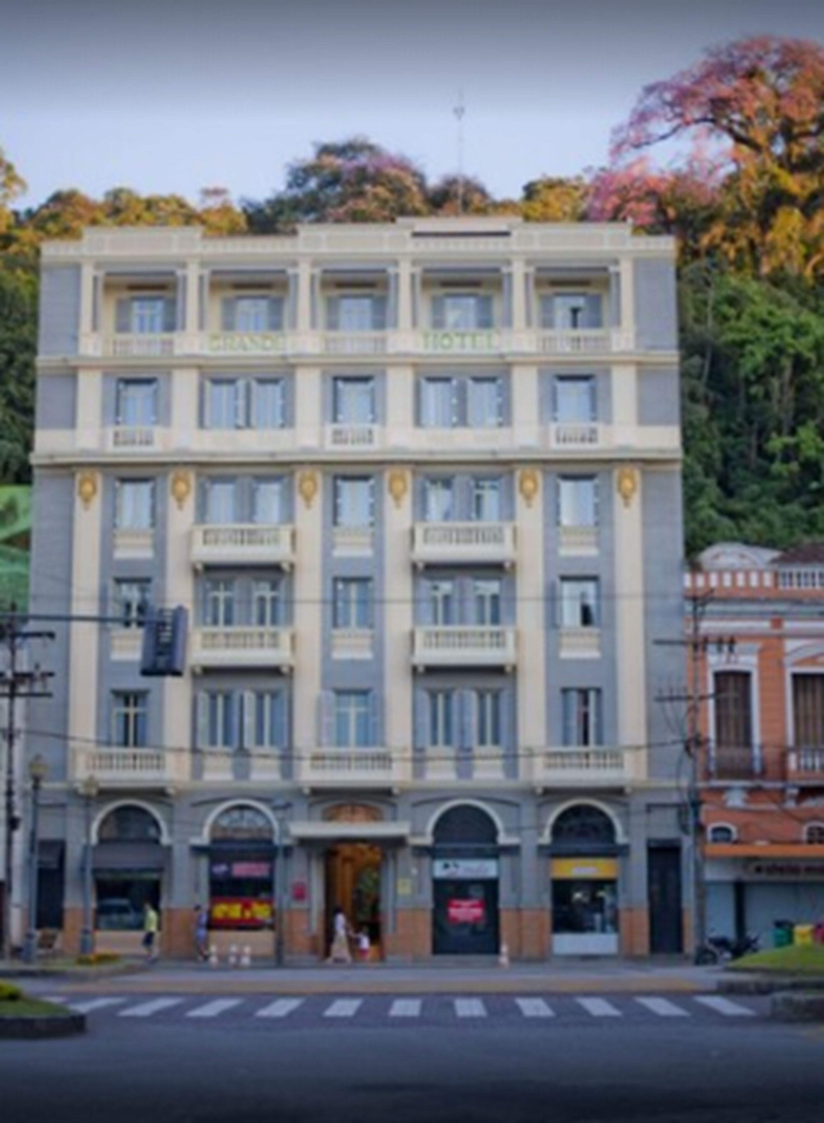 Un hotel de varios pisos con una fachada simétrica, ventanas distribuidas de forma uniforme y una entrada central.