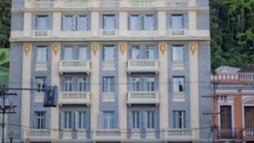 Un hotel de varios pisos con una fachada simétrica, ventanas distribuidas de forma uniforme y una entrada central.