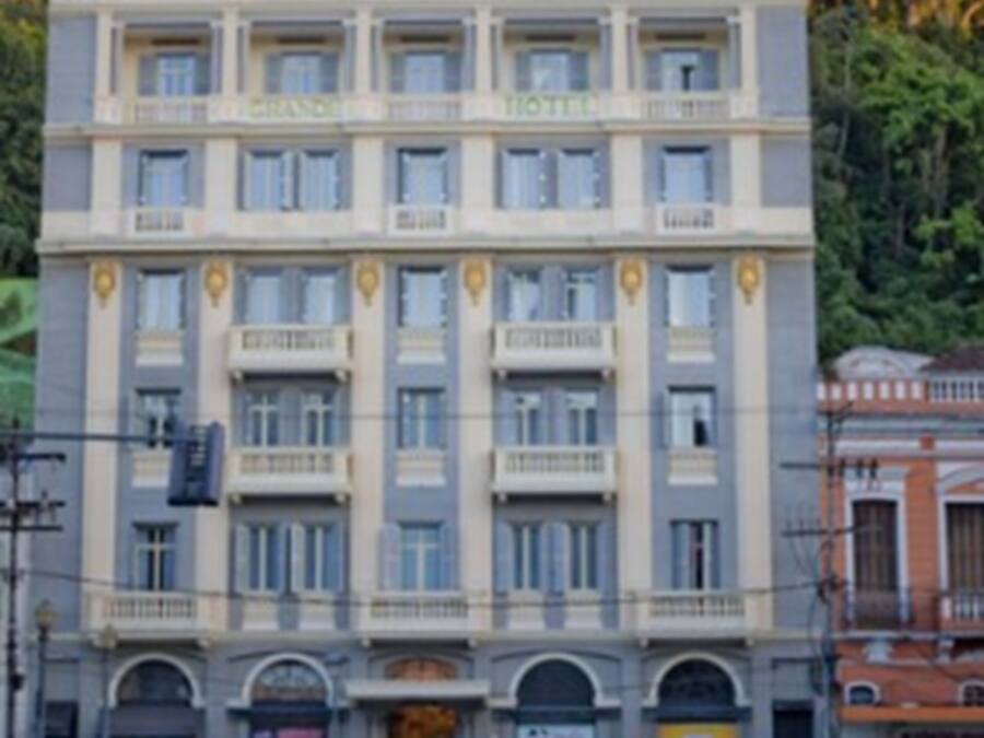 Un hotel de varios pisos con una fachada simétrica, ventanas distribuidas de forma uniforme y una entrada central.