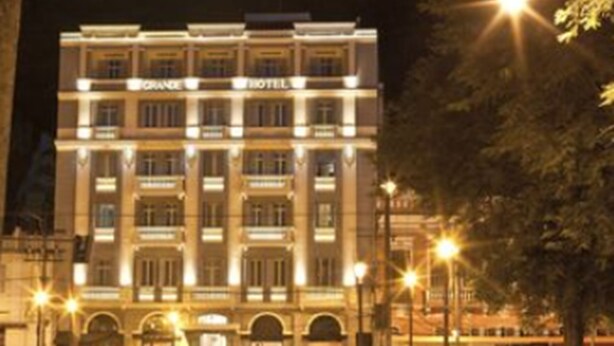 Un hotel de varios pisos con estilo arquitectónico clásico, que cuenta con una entrada central y numerosas ventanas en cada planta.