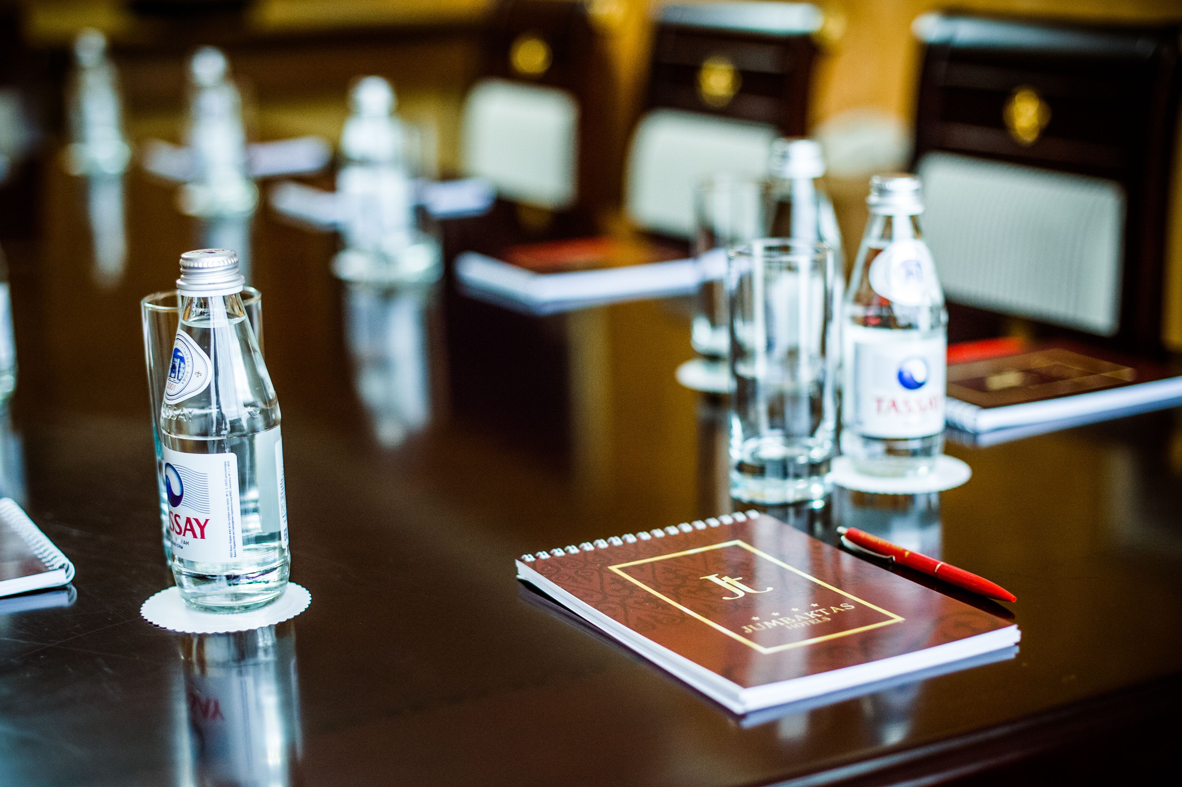 A hotel reception desk with water bottles, a notepad, and a pen.