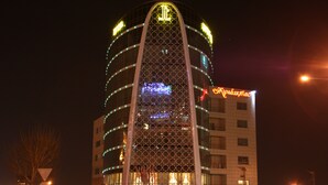 A hotel with a distinctive triangular facade and illuminated signage. - Jumbaktas Hotel (Astana)