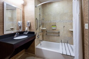 Une salle de bain moderne équipée d’un lavabo, d’un miroir, d’une douche et d’une baignoire.