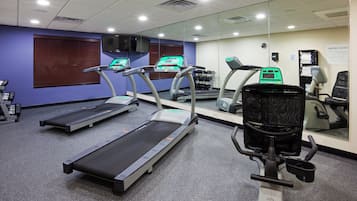 A gym with treadmills, a stationary bike, and a mirrored wall.