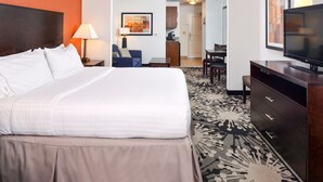 Une chambre d’hôtel dotée d’un grand lit, d’un bureau, d’une télévision et d’un coin repas.