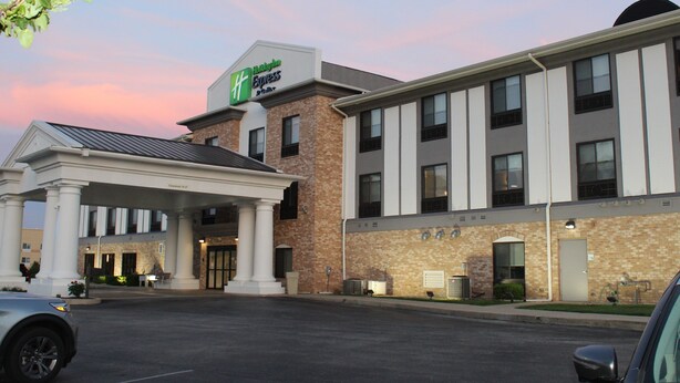 Un hôtel à la façade en briques, doté d’une entrée couverte et d’une enseigne indiquant qu’il s’agit d’un Hampton Inn Express.
