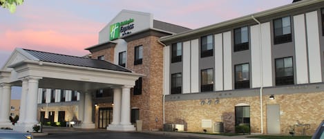 A hotel with a brick facade, a covered entrance, and a sign for the Hampton Inn Express.