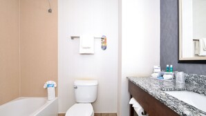 Une salle de bain équipée d’une baignoire, de toilettes et d’un meuble-lavabo avec un évier et un miroir.