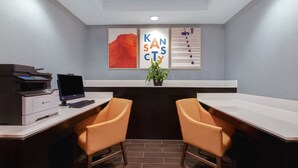 Een moderne kantoorruimte met een bureau, twee stoelen, een printer en lijstwerk aan de muur.