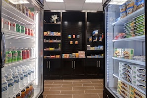Vitrine refrigerada com diversas bebidas e lanches.