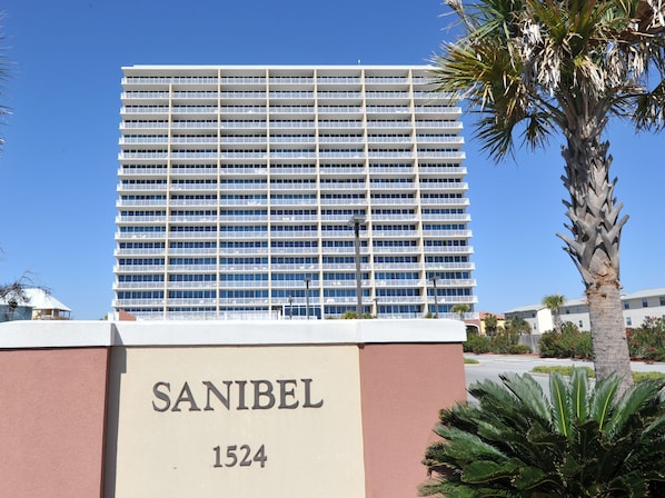A modern hotel with a large, multi-story building and a sign reading "SANIBEL 1524".
