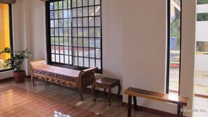 A room with a bed, a small table, and a window with a view of the outside. - Sea Jewel Beach Resort Puerto Galera (Puerto Galera)
