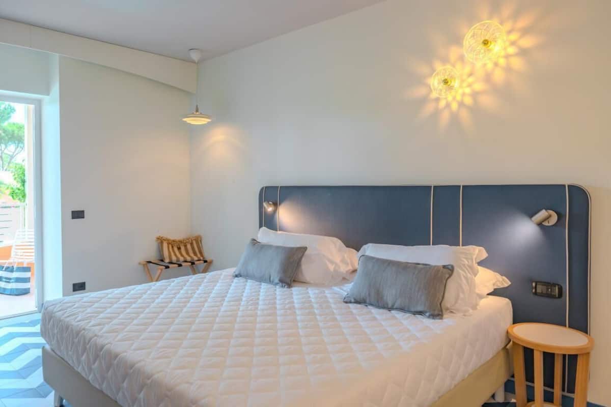 A modern bedroom with a large bed, a small round table, and a chair.