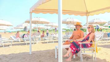 A beach with sun loungers and umbrellas.