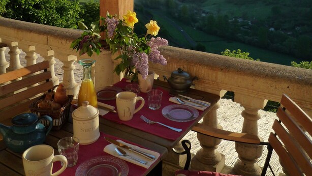 Una mesa lista para el desayuno con vistas a colinas onduladas.