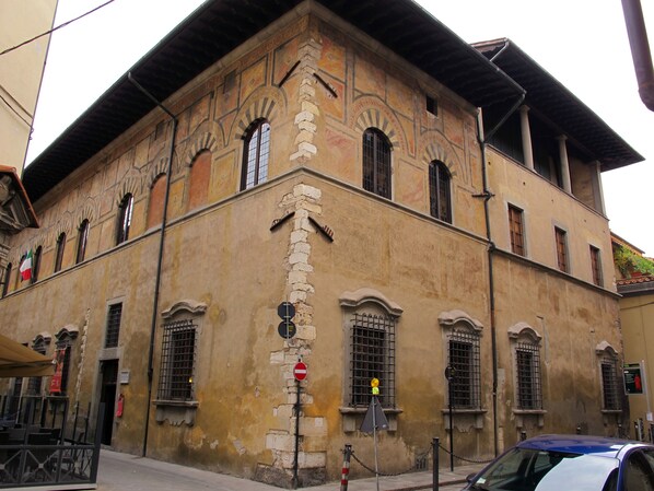 A historic building with a traditional facade, multiple windows, and a corner entrance.