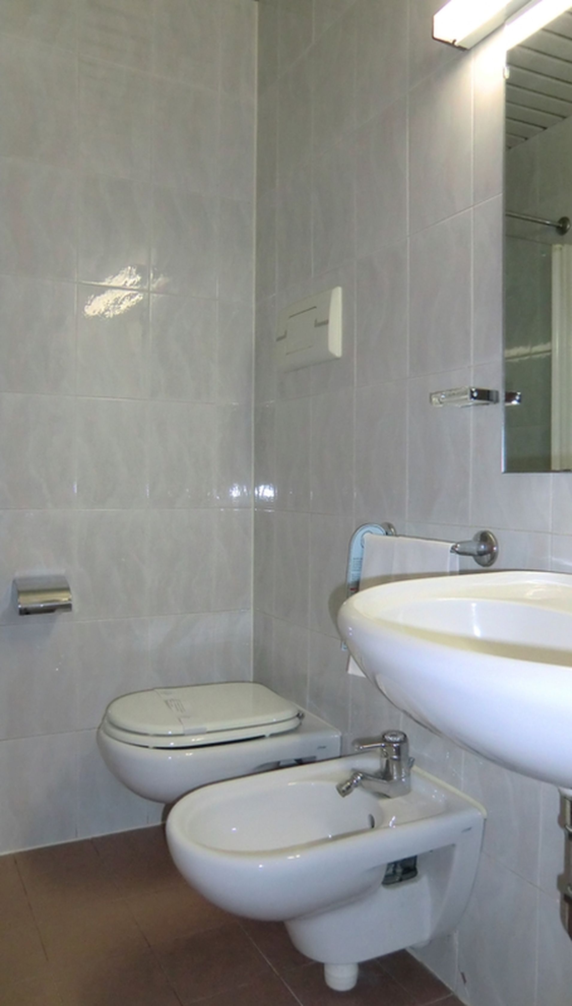 A bathroom with a toilet, bidet, and sink.