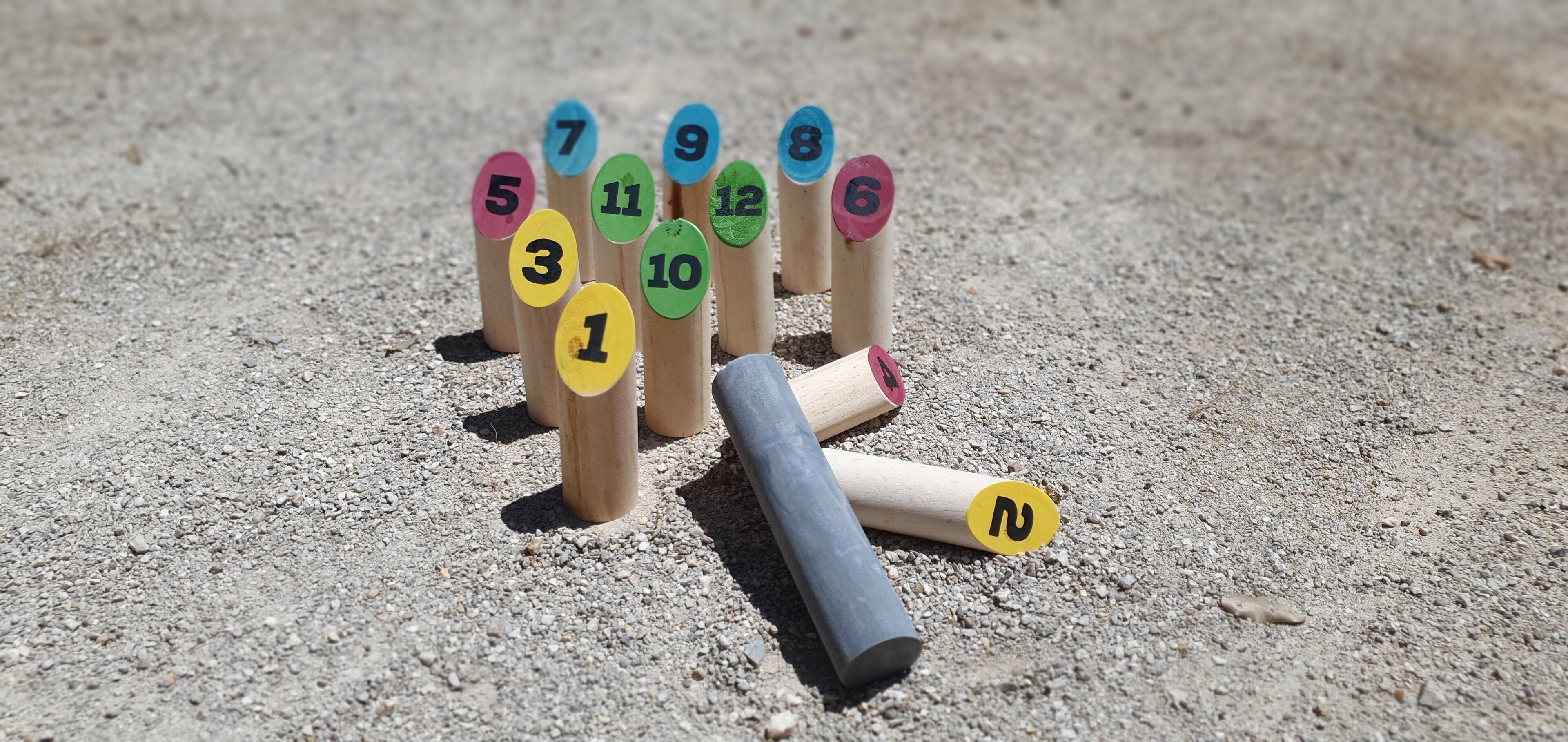 Un ensemble de bâtonnets en bois numérotés, placés sur une surface de gravier.