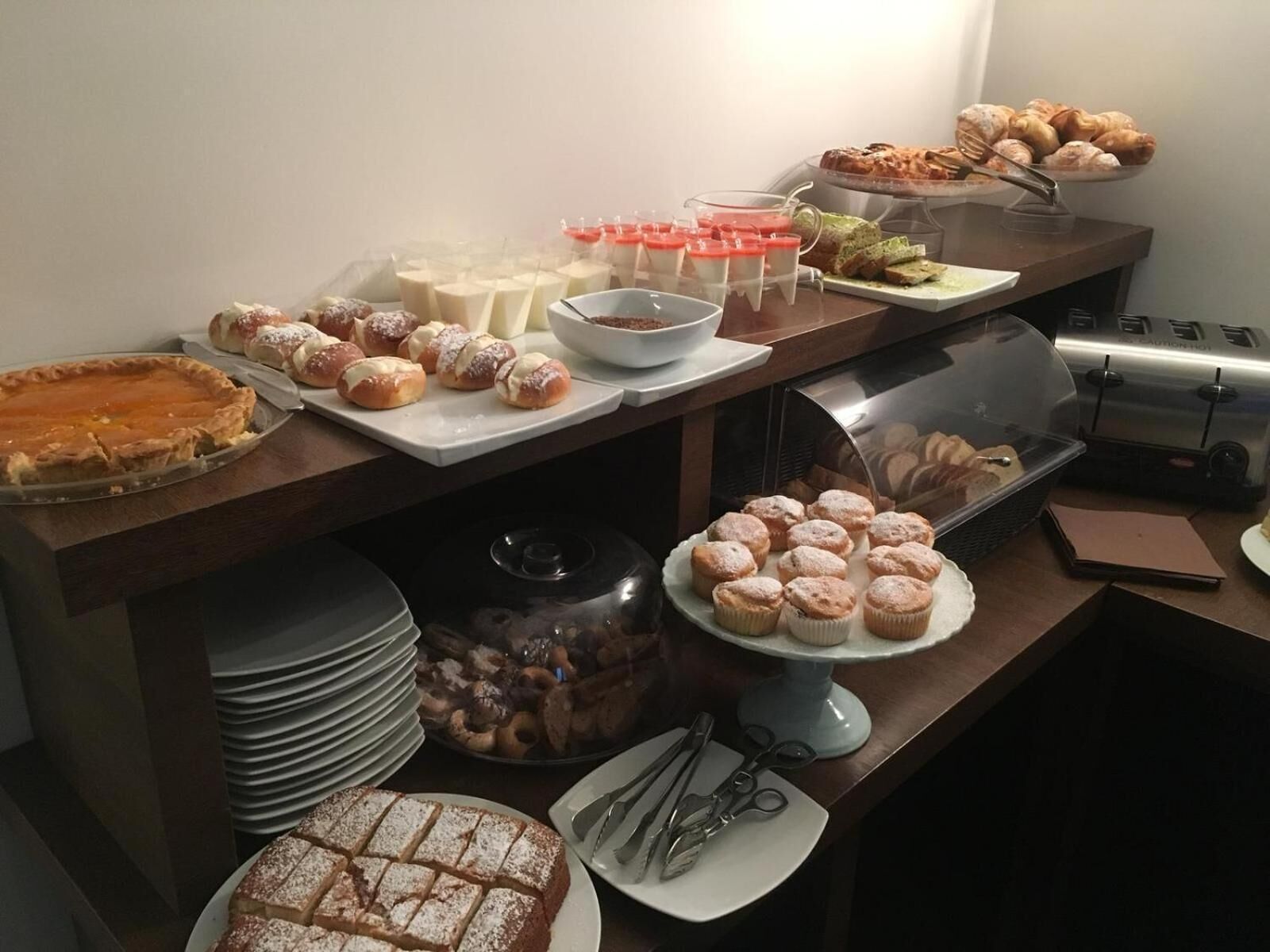 Un tavolo per buffet con diversi dolci, tra cui torte, pasticcini e muffin.