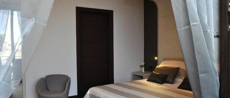 Een moderne slaapkamer met een bed, een stoel en een deur.