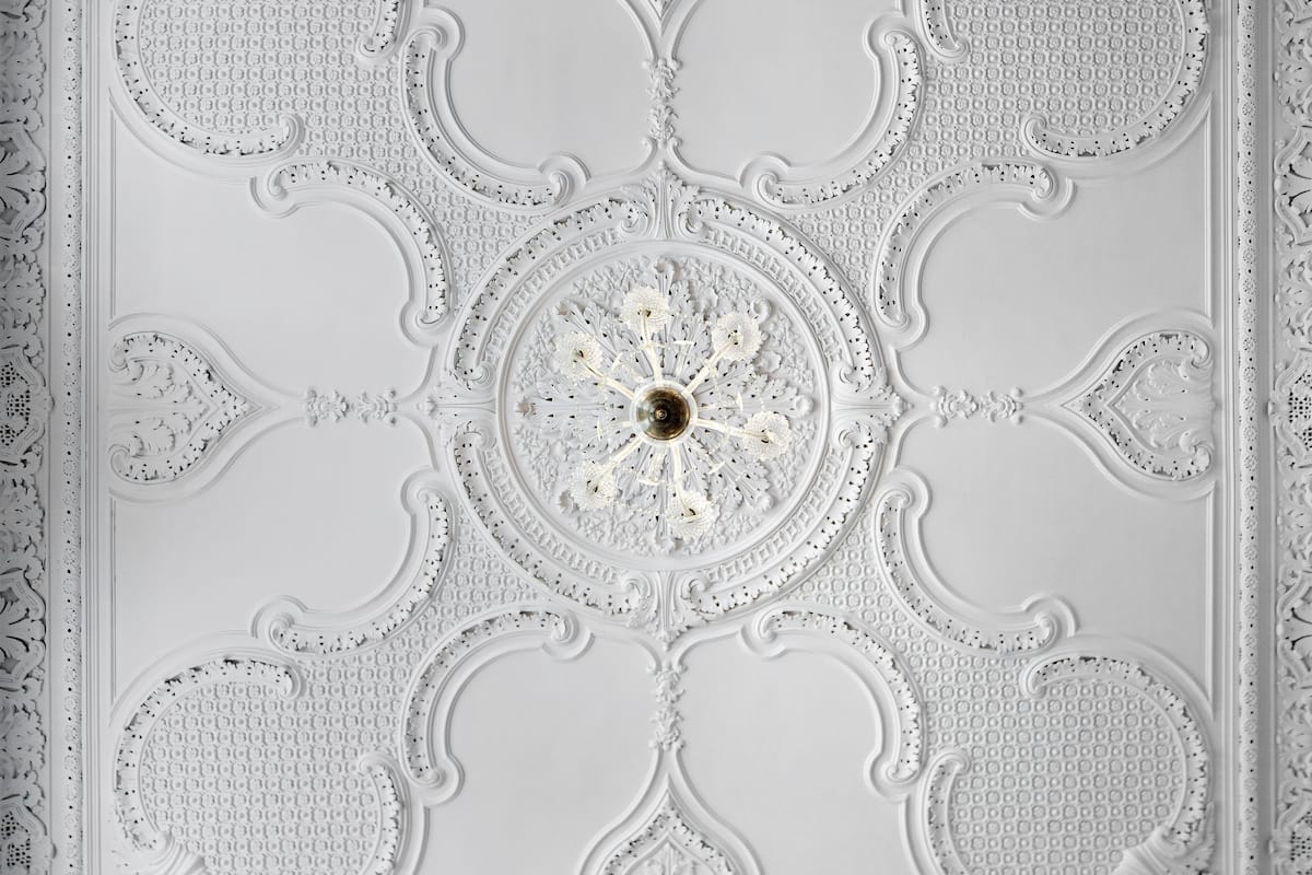 A detailed ceiling with ornate patterns and a central circular design.