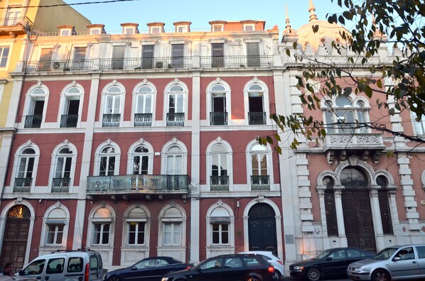 Un edificio de varios pisos con ventanas arqueadas y balcones.