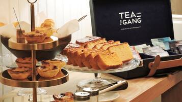 A buffet table with pastries and a tea and coffee station.