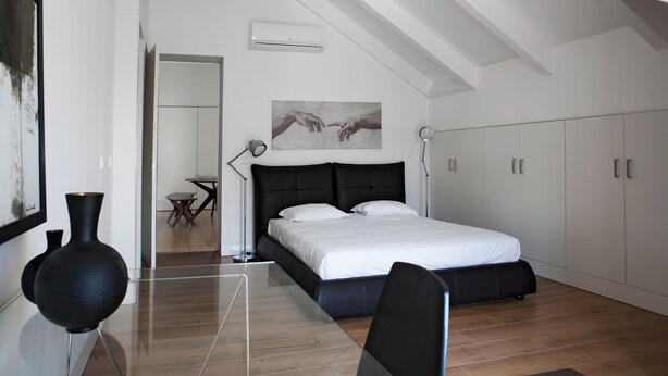 Una camera da letto moderna con un letto grande, una scrivania e una sedia.