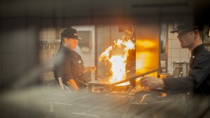A chef cooking with a large flame on a stove in a kitchen. - Hotel Gasthof Goldener Adler (Schwäbisch Hall)