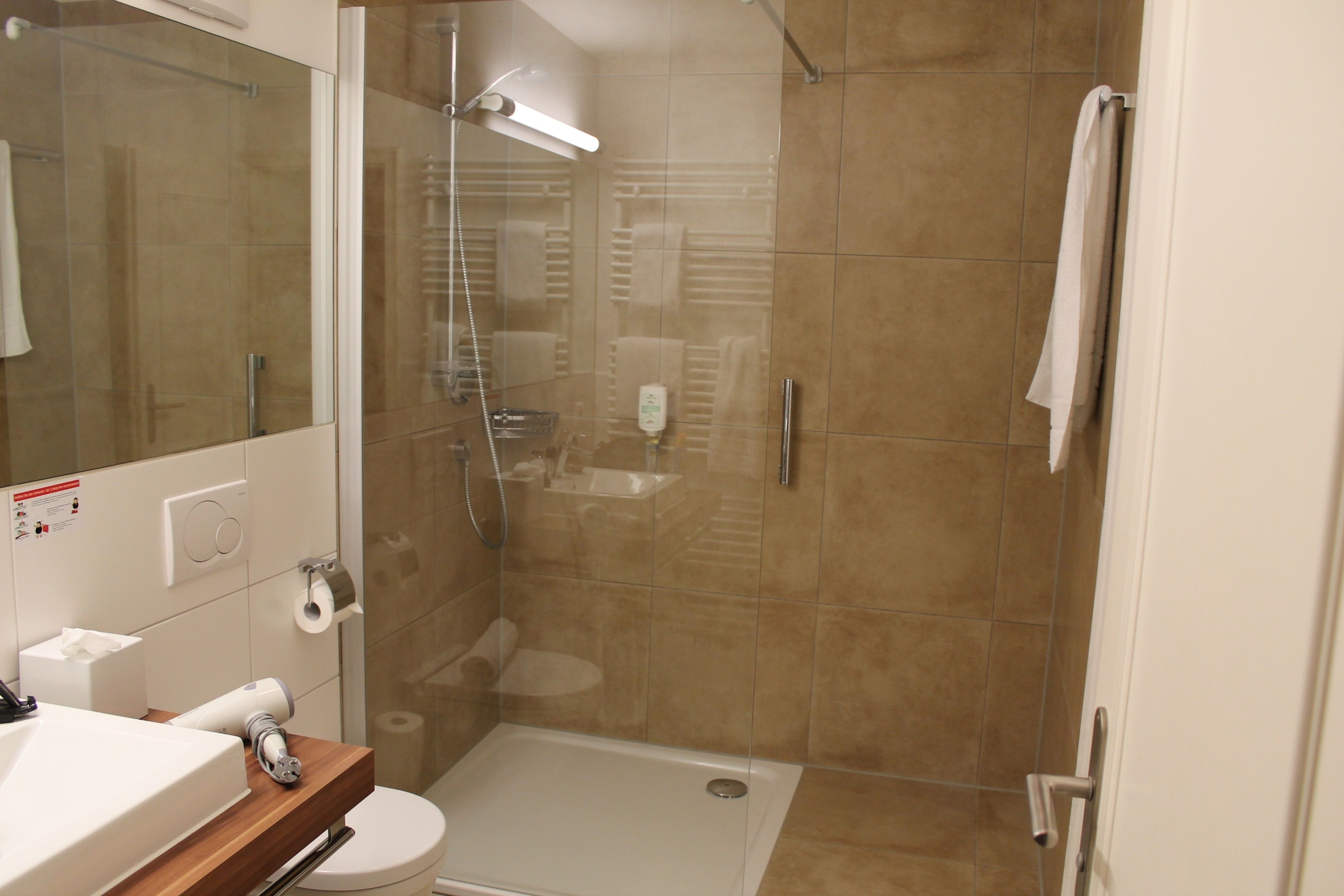 A modern bathroom with a shower, toilet, and sink.
